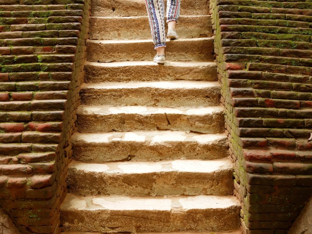 girl walking up the stairs to sigiriya rock in sri lanka