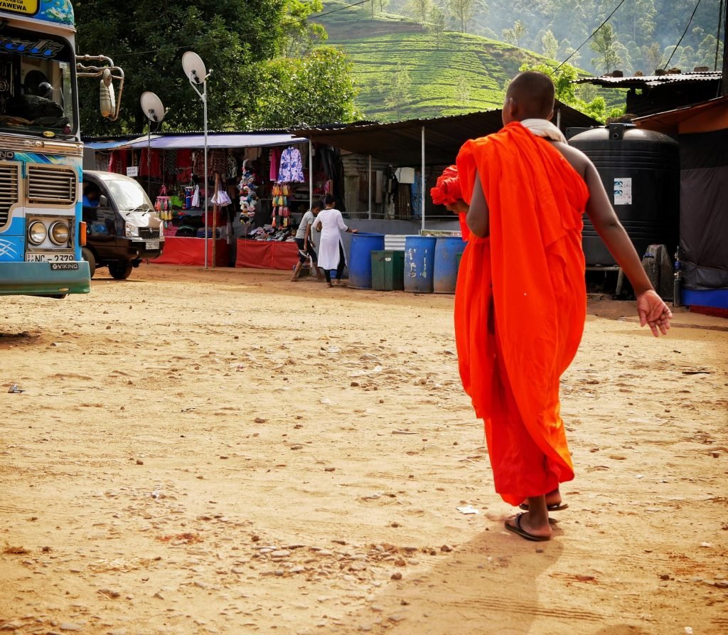 sri lankean monk near adams peak walking and wearing a red rop