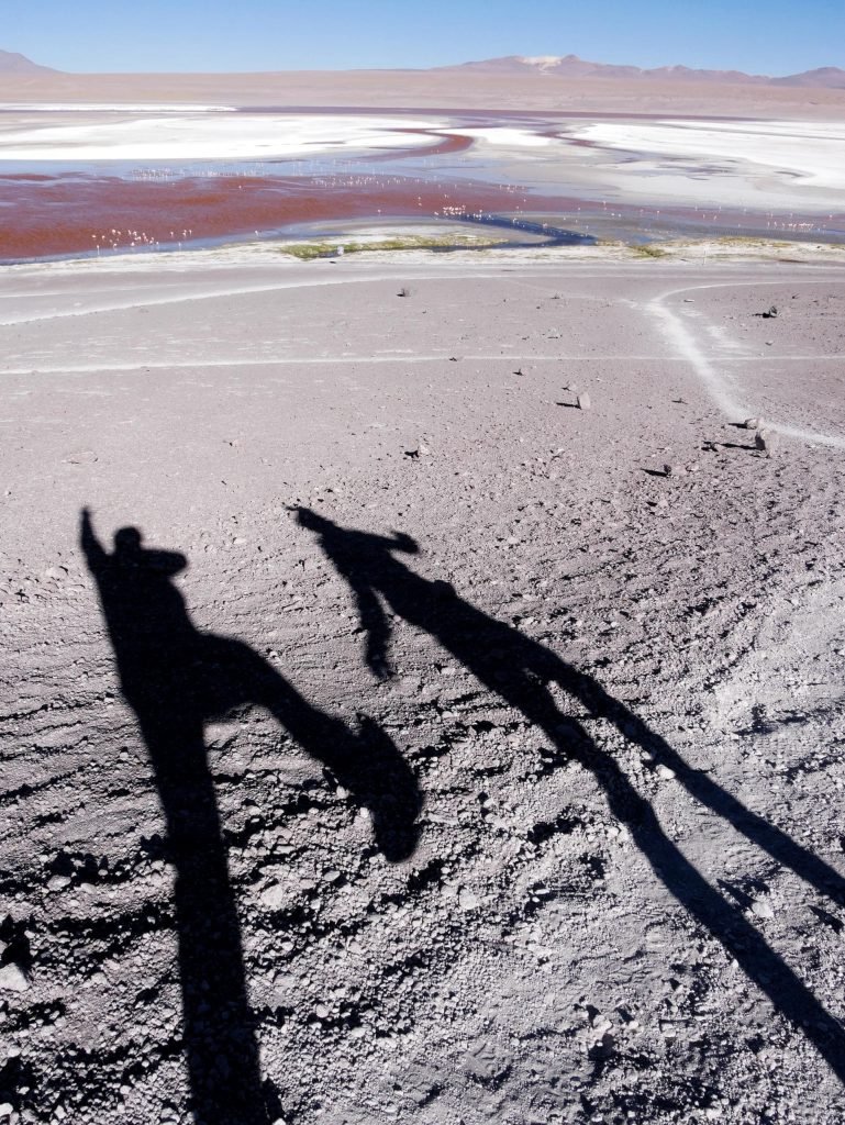 shadows of two people at a salt lagoon in Bolivia