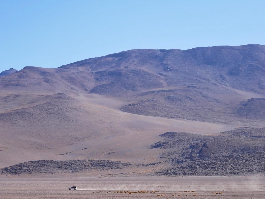 a toyota land cruiser driving in the landscape of atacama desert Bolivia