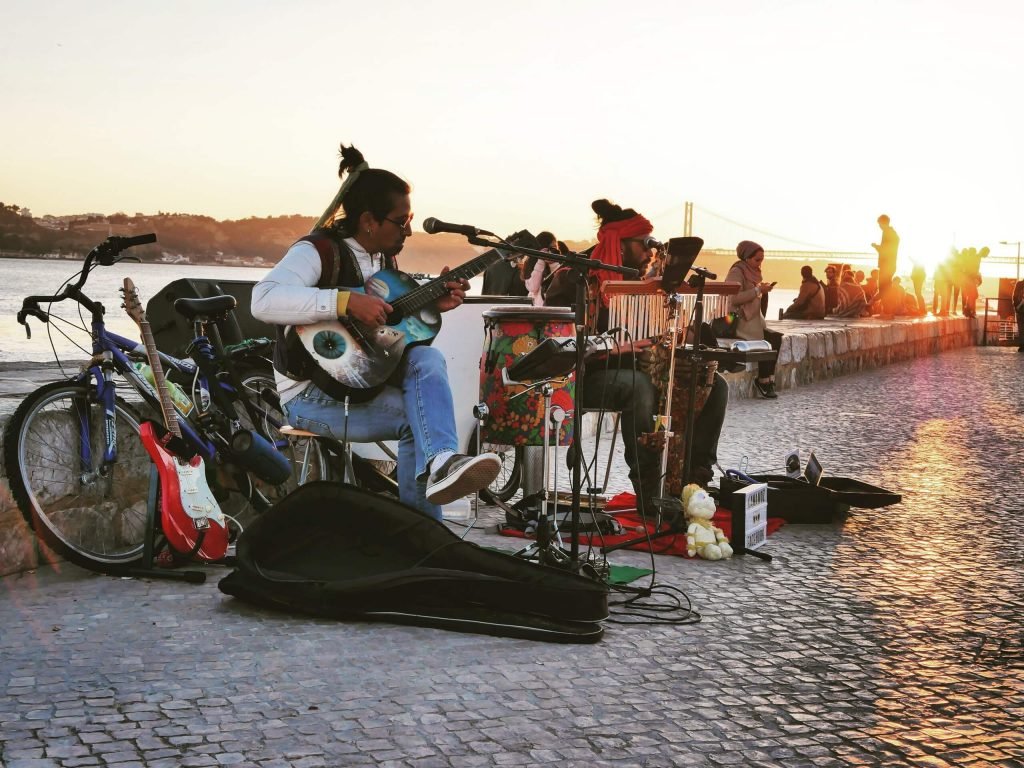 a street musician at the coast of Lisbon, Portugal playing guitar