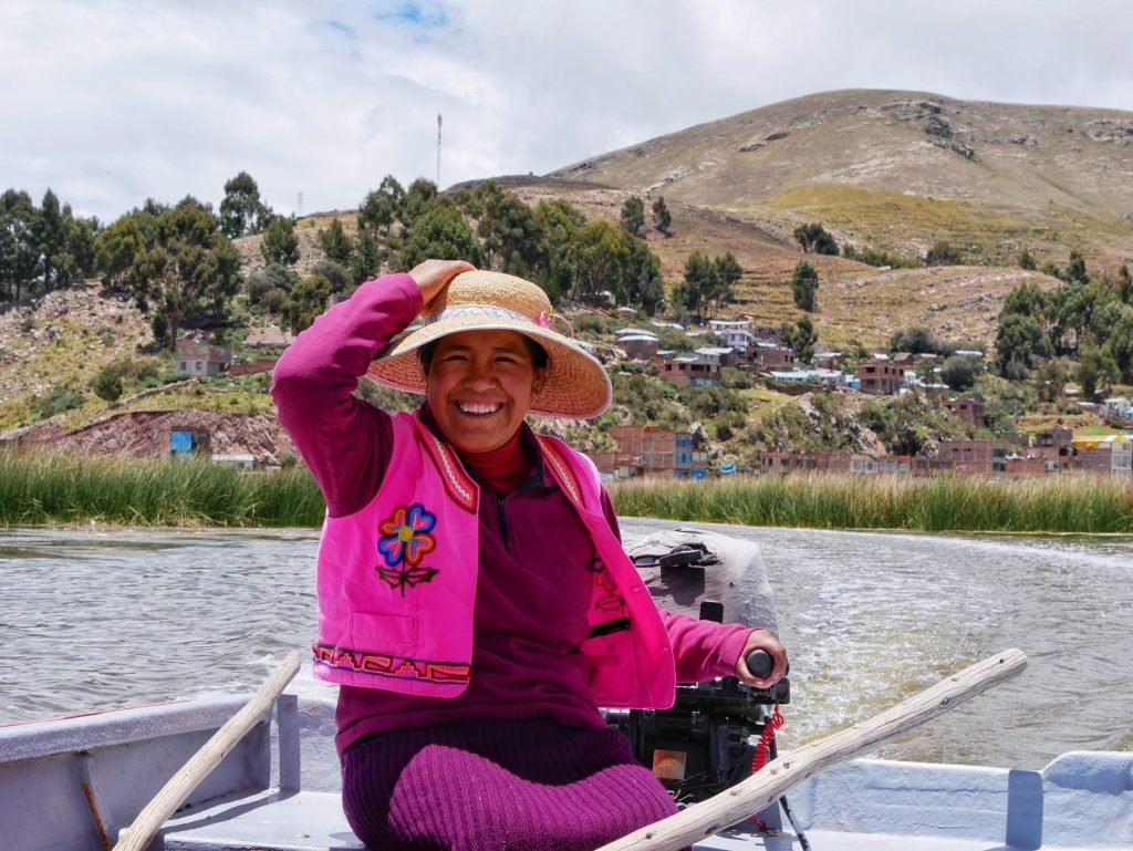 An Uros women driving a boat on Lake Titticaca