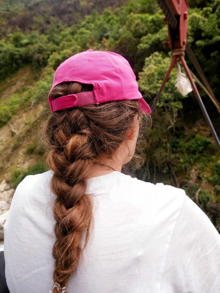 Girl from behind with pigtail and pink cap