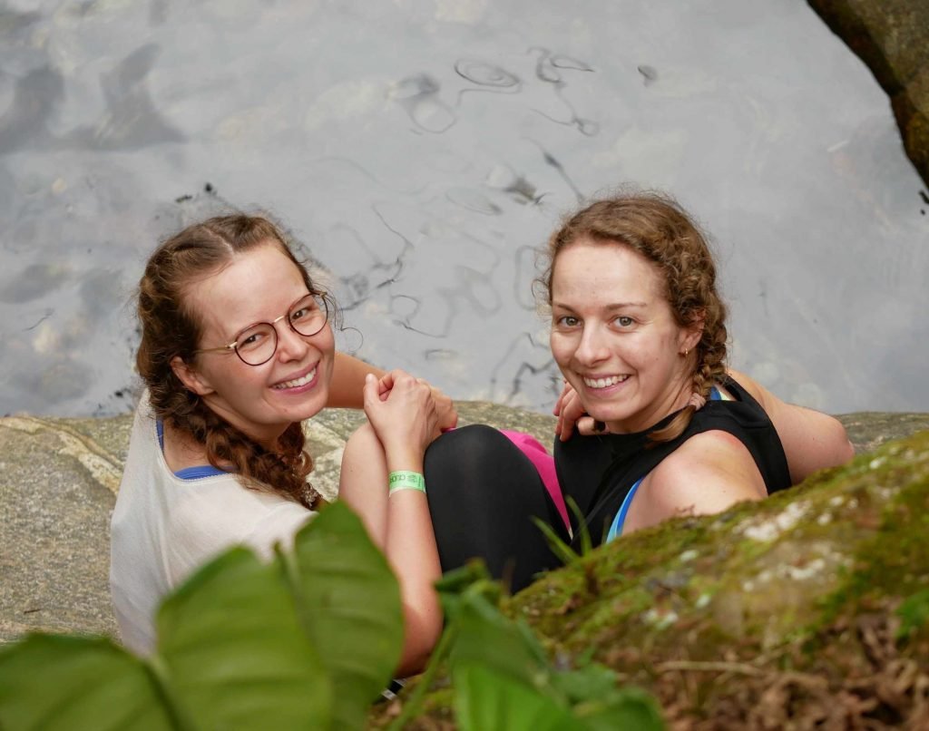 two girls relaxing by the river after hiking